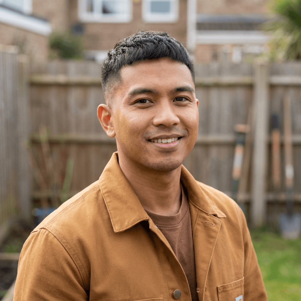Michael Tran, male homeowner in his mid 30s, East Asian, smiling in a bright living room after a fresh interior paint job